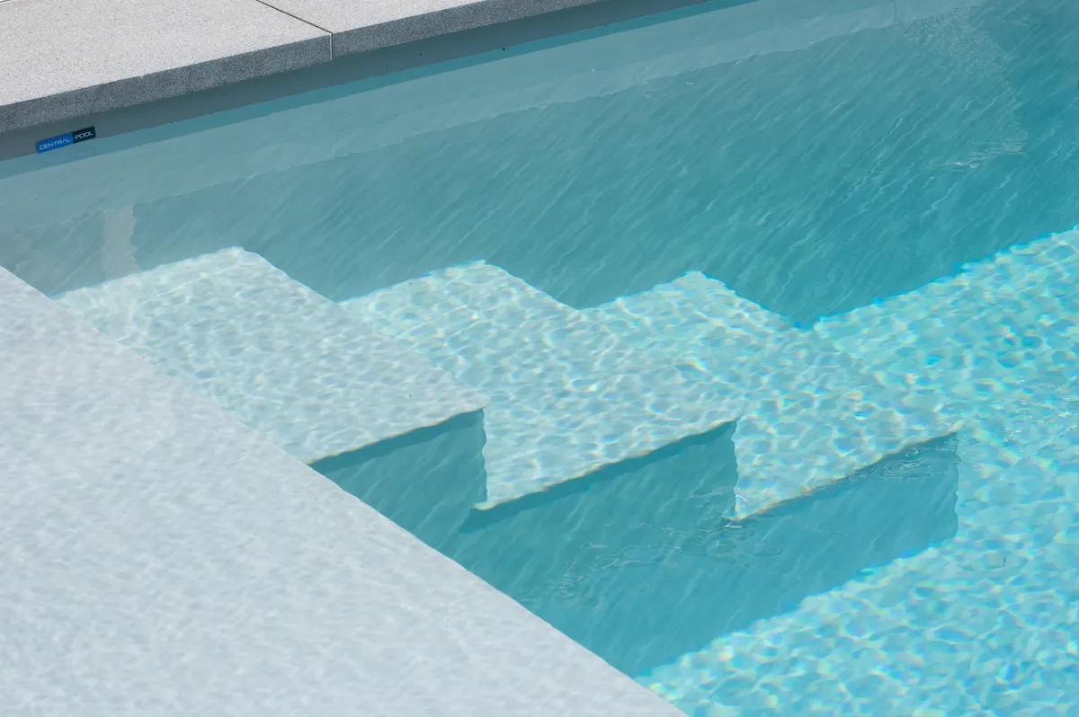 Installed pool stairs with clear blue water